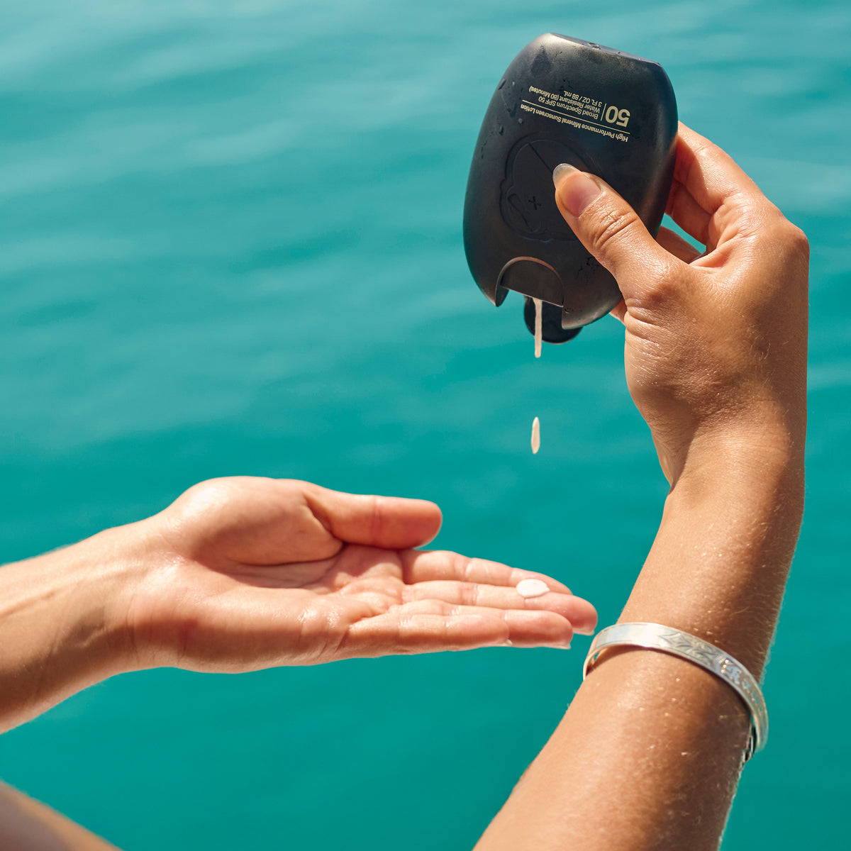 Person using a water quality tester over a body of water